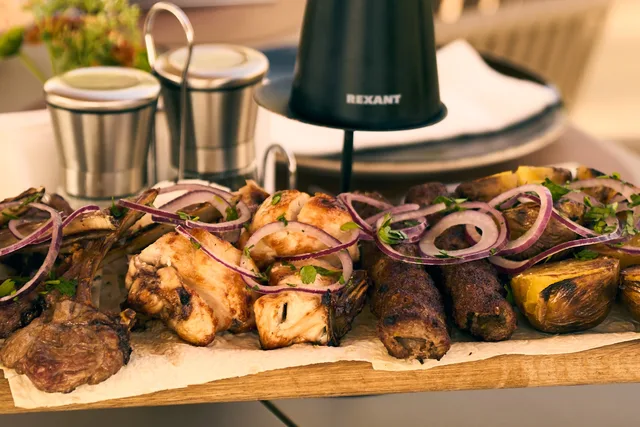 Мясо и овощи с мангала с красным луком на доске